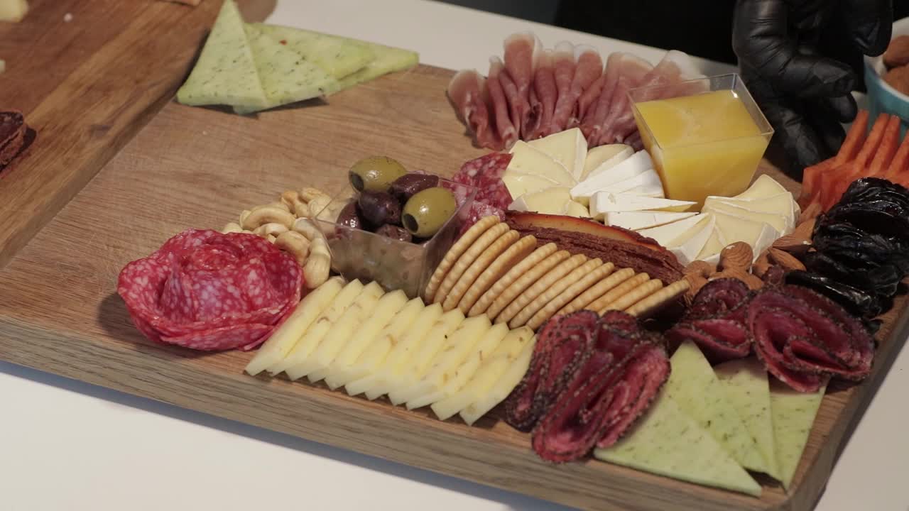 开胃菜板上有各种奶酪，肉，葡萄和坚果。熟食和奶酪拼盘。视频素材