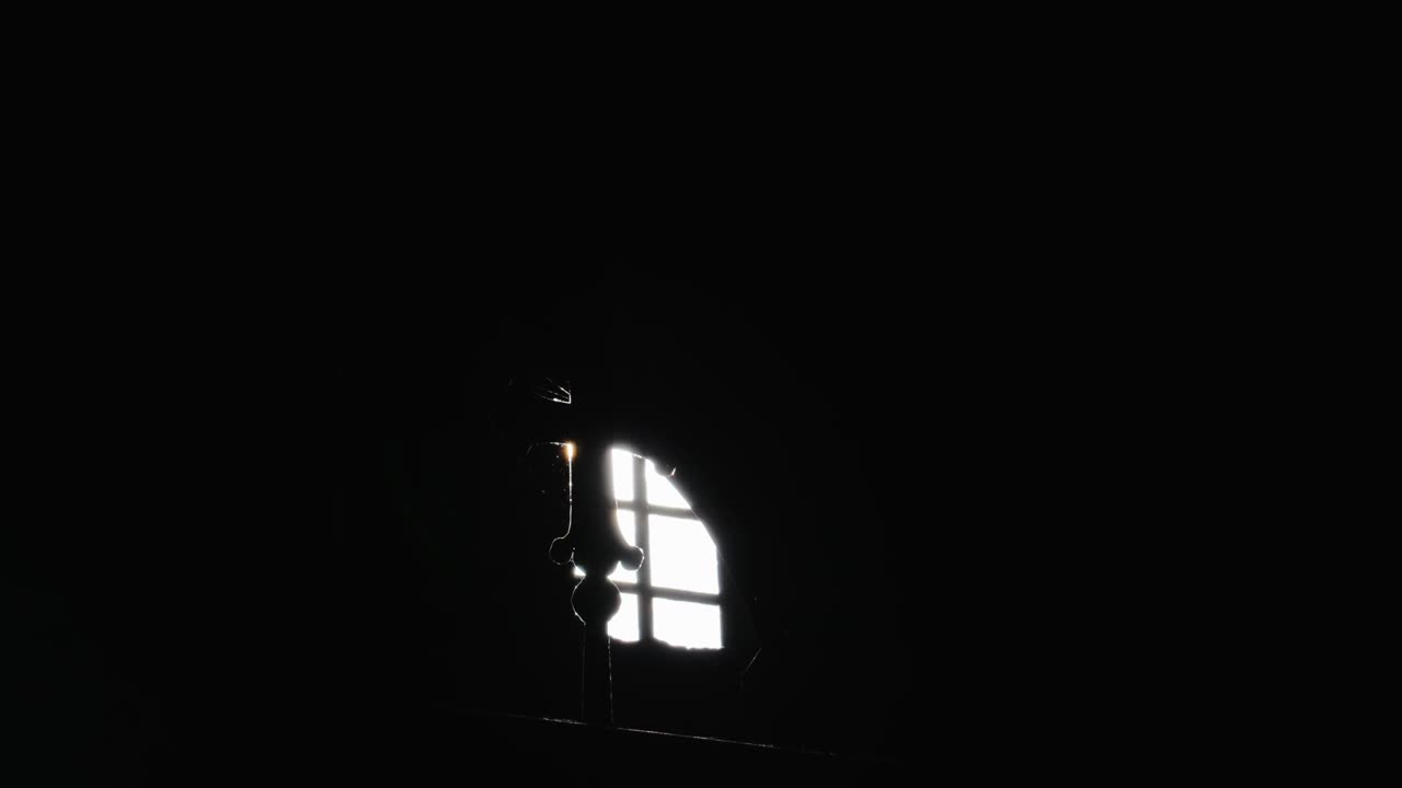 一个正统的十字架的剪影在一缕阳光从一个小窗口视频素材