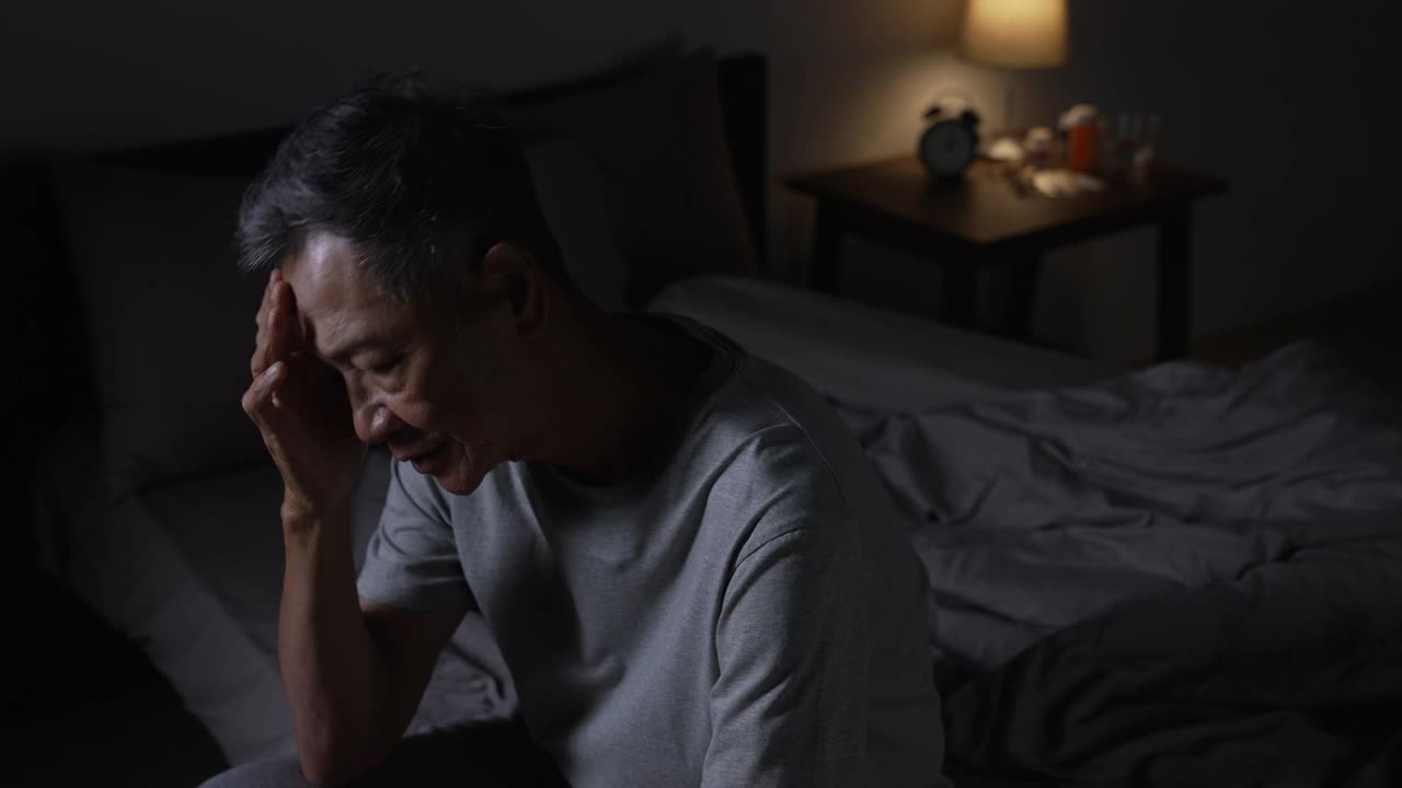 抑郁的亚洲老年男子因失眠而无法入睡。视频下载