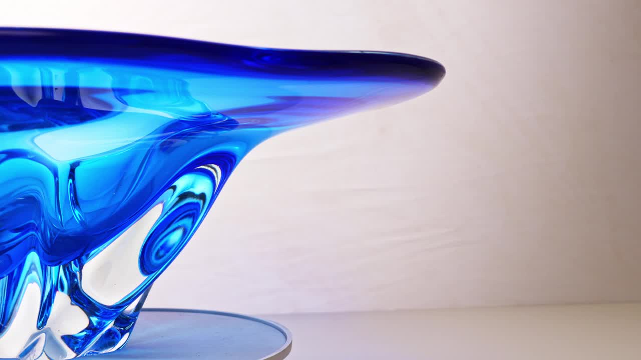 旋转。一个用蓝色玻璃做成的漂亮的大盘子。视频下载