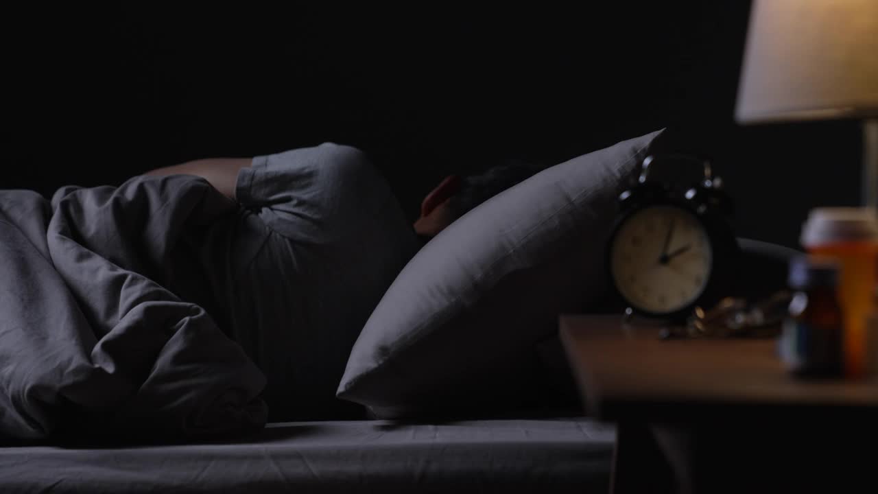 抑郁的亚洲老年男子因失眠而无法入睡。视频下载