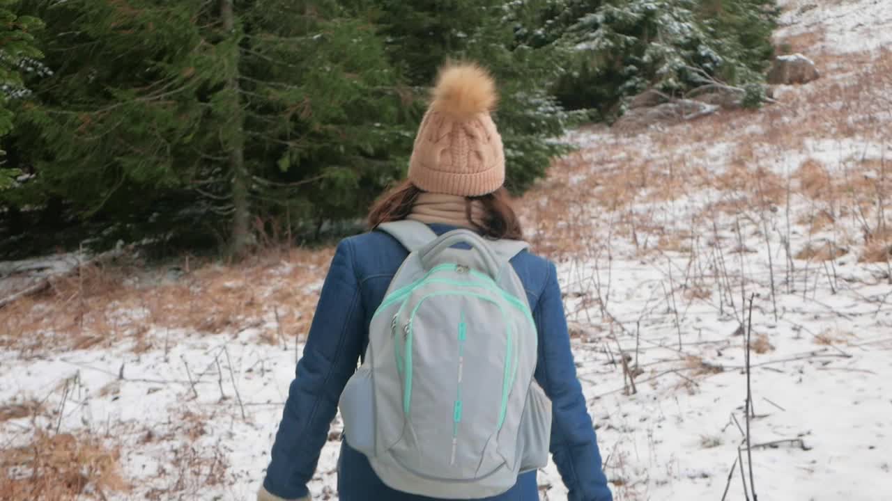 女人上山，雪和冬天。背包旅行者。视频下载