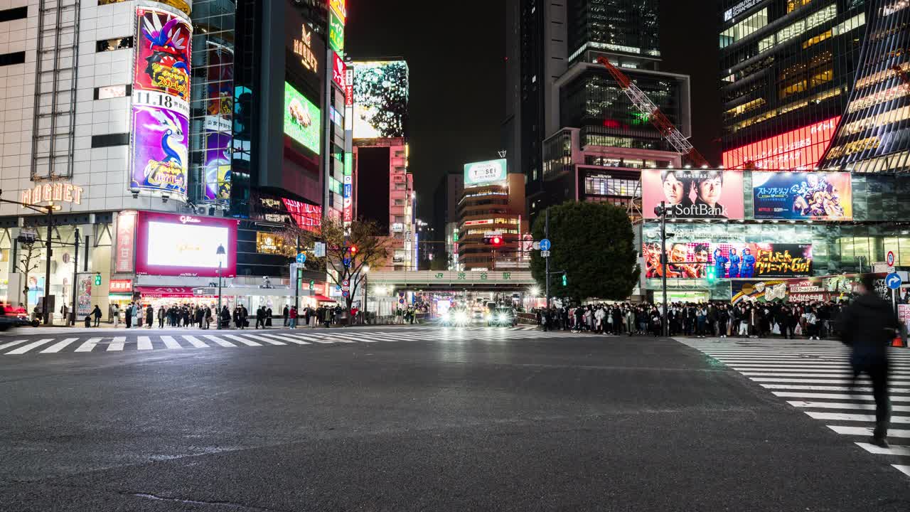 夜间时间流逝的汽车交通运输，拥挤的人走在涩谷路口的十字路口争抢。东京旅游景点地标，日本旅游，亚洲交通或亚洲城市生活理念视频下载