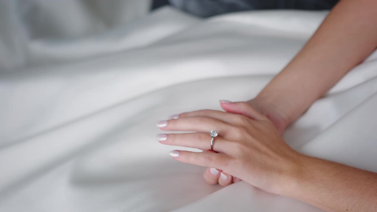 新娘的手与结婚戒指紧密结合白色婚纱。新娘的准备，新娘的早晨。视频下载