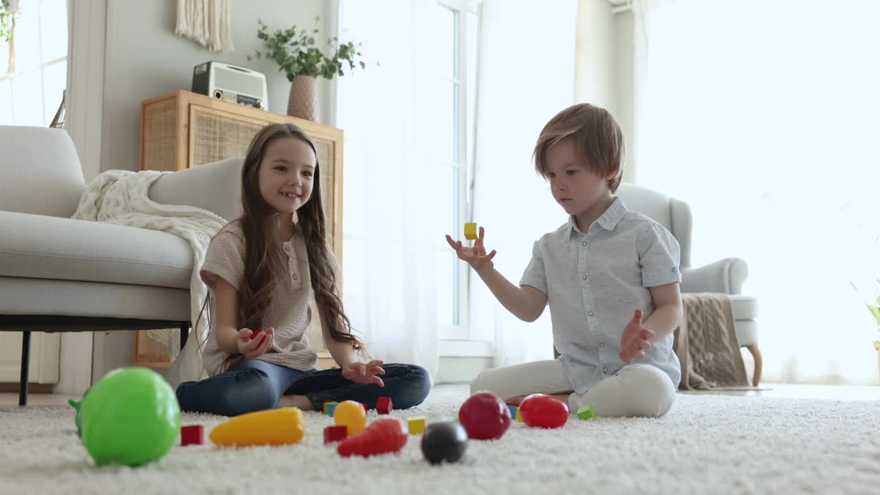 两个可爱的孩子在家里玩，玩彩色的木砖视频下载