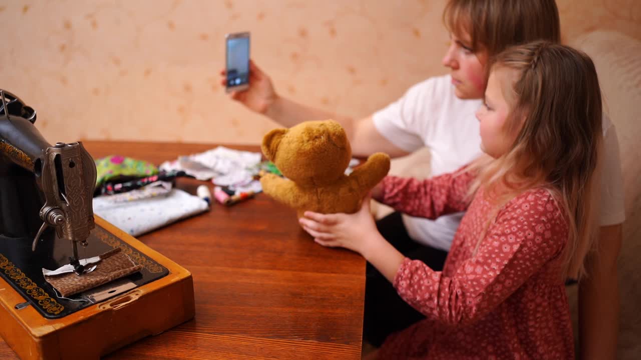 母亲和女儿用智能手机拍下修复后的玩具视频下载