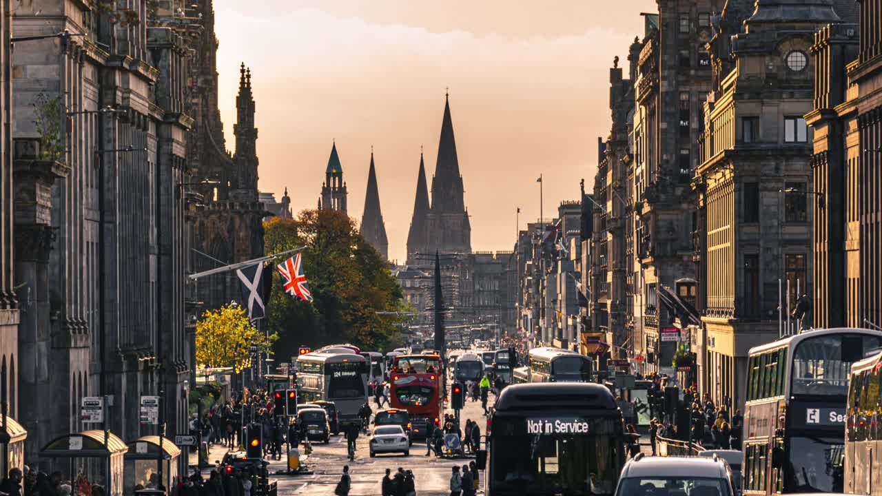 在爱丁堡王子街的斯科特纪念碑周围，人群行人和游客步行和穿越公共汽车交通的时间推移视频素材