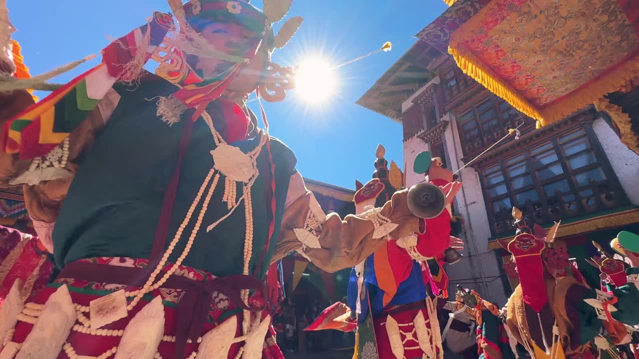 在当地人群面前，穿着全套文化服装的不丹占族舞者在修道院广场上表演的彩色仪式镜头。视频下载