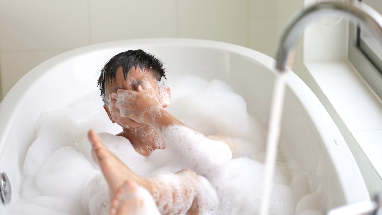亚洲孩子在酒店的浴缸里带着通气管面罩和黄鸭子玩得很开心。健康和幸福的概念视频下载