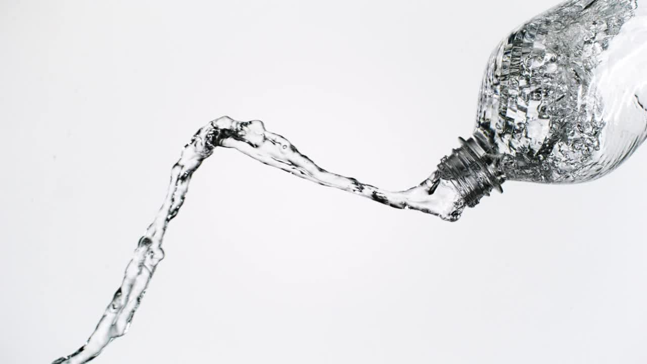 近距离和超级慢动作的倾倒和飞溅晶莹剔透的水从一个摇晃的水瓶在白色背景在通用的水平和垂直格式视频素材