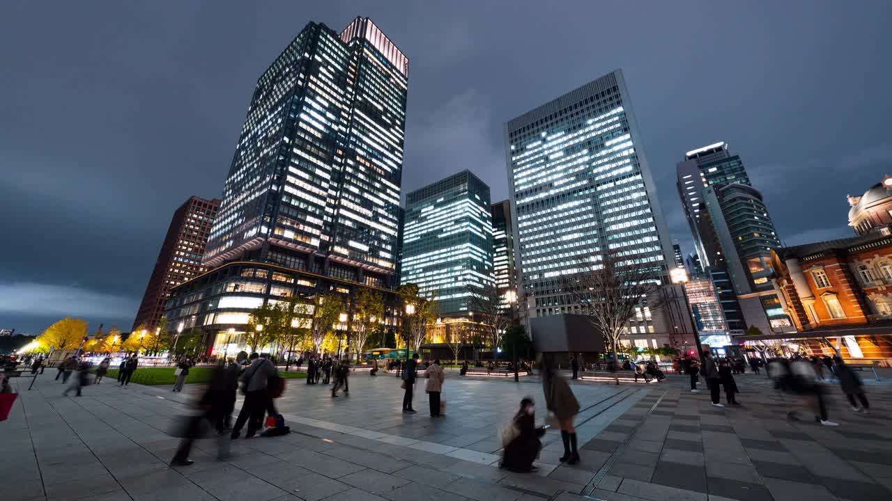 夜间时间流逝拥挤的人群步行，汽车交通运输在丸之内金融商业区在东京。日本的工作方式，日本的经济，亚洲的交通或亚洲的城市生活视频下载