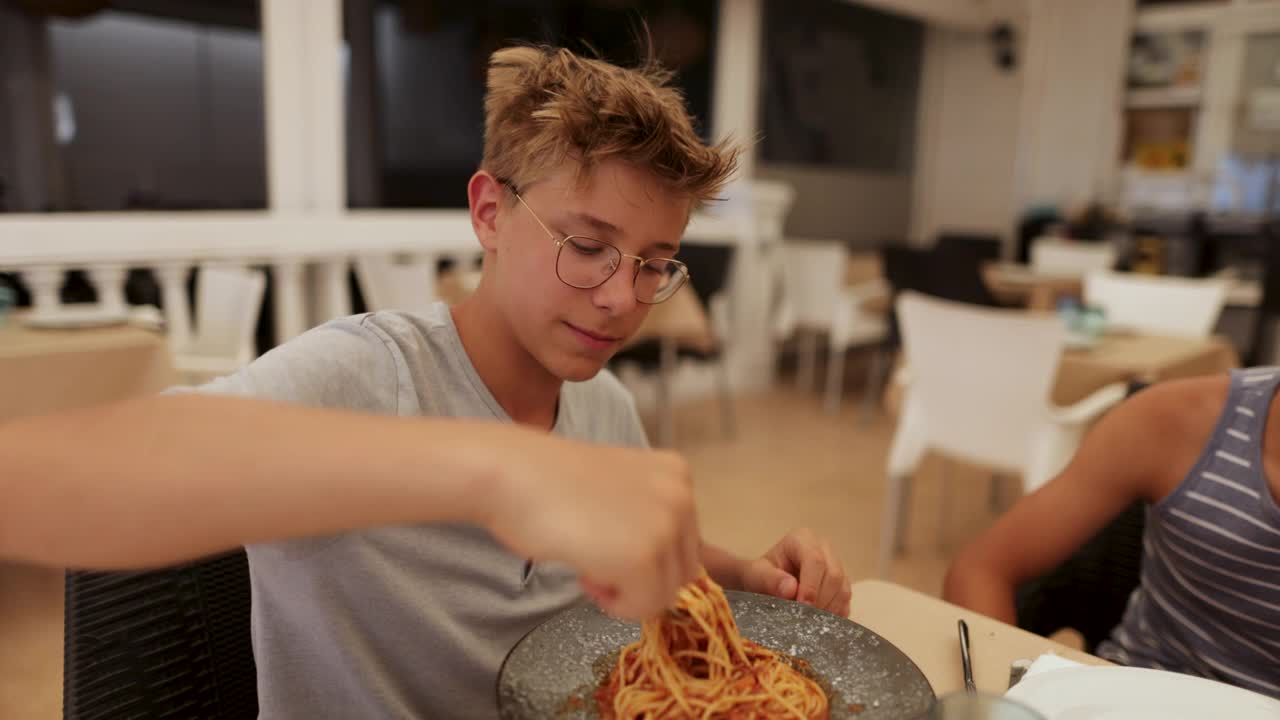 十几岁的男孩吃了太热的意大利面视频素材