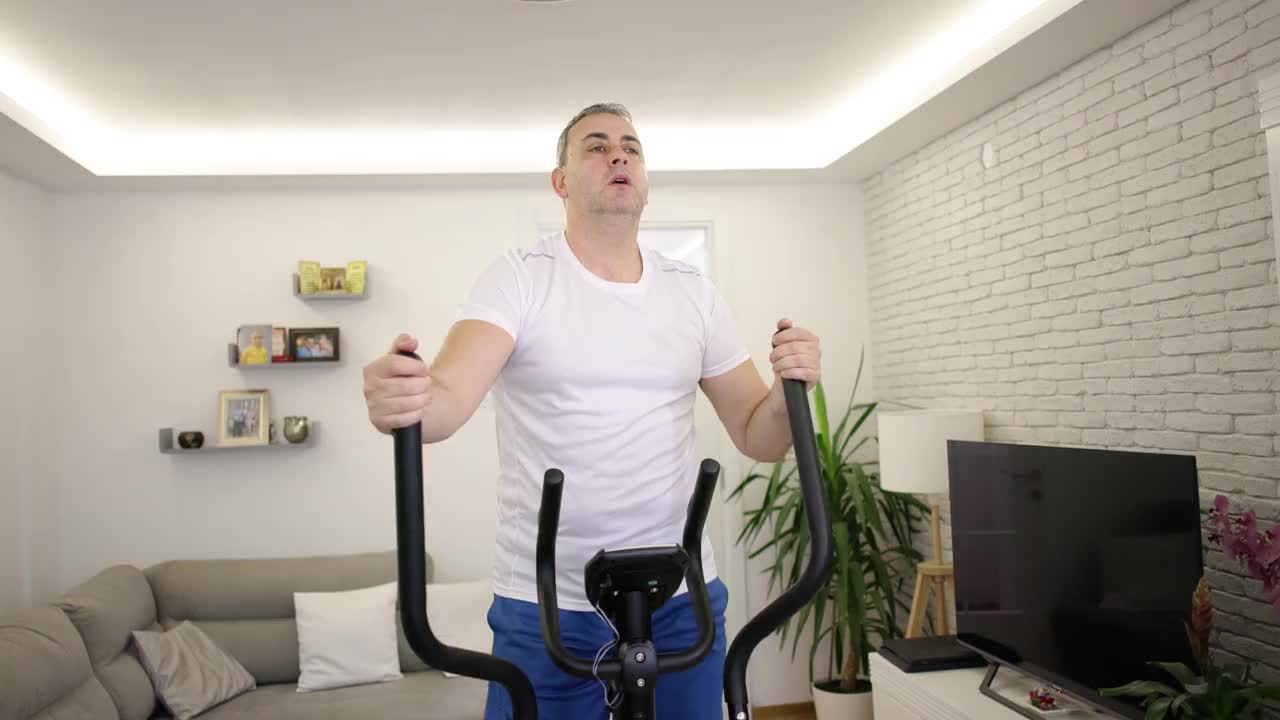 一名男子在客厅的北欧滑雪健身机上锻炼视频下载