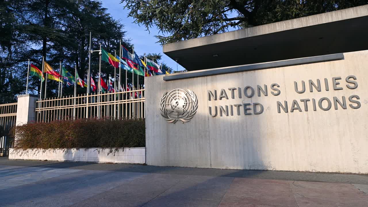 2023年1月，瑞士日内瓦。联合国总部的录像:明显的标志和法文和英文的“联合国”字样。左边是成员国的国旗。视频下载