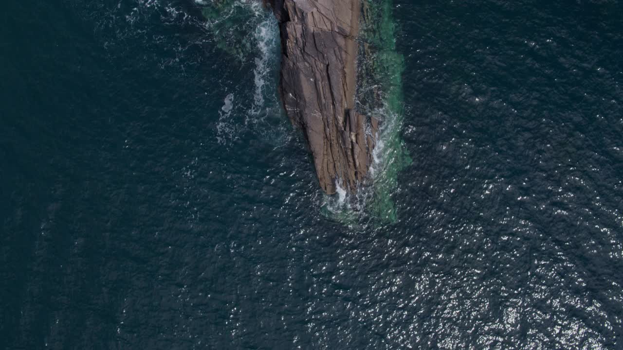 高空航拍海浪溅在海洋中的岩石上视频下载