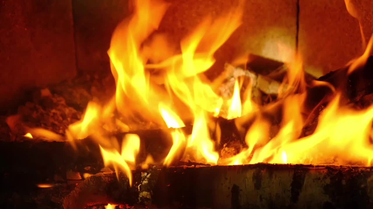 特写镜头下，柴火正在炉膛里燃烧。替代环保供暖，温暖舒适的房间在家里，燃烧木材视频素材