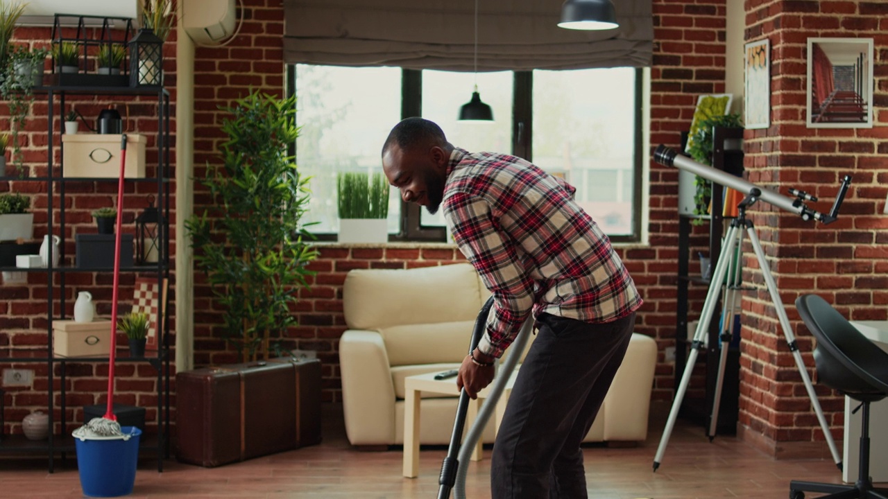 非裔美国伙伴使用真空吸尘器清洁客厅灰尘视频素材