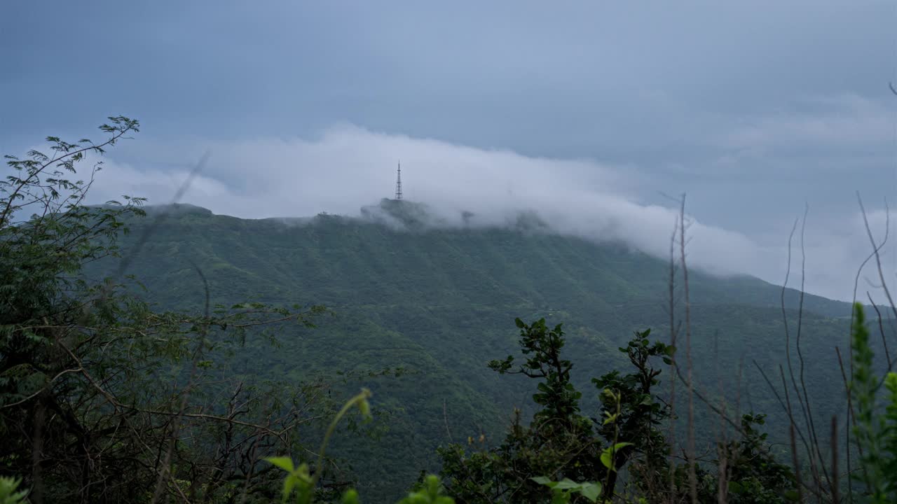 印度马哈拉施特拉邦辛格加德，西高止山脉的云雾翻滚，露出山顶上的一座塔视频下载
