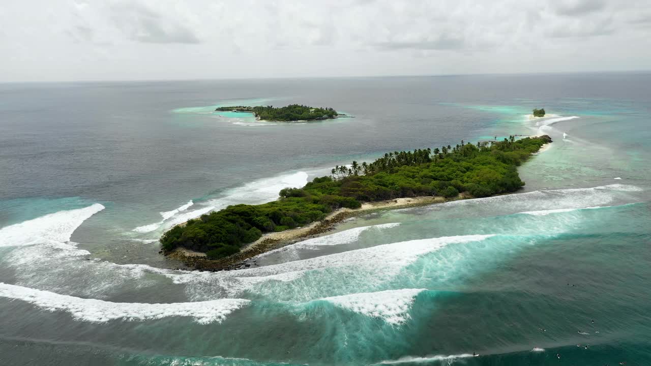 航拍海浪在海面上飞溅的岛屿对着天空，无人机在海洋上空上升- thulushoo，马尔代夫视频素材