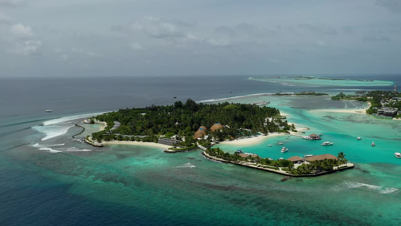 空中平移拍摄的岛屿与旅游胜地和港口对着天空，无人机在晴天飞越海洋-马尔代夫的thulushoo视频素材