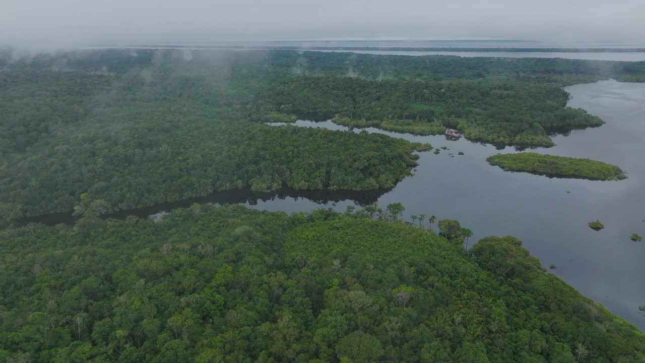 航拍的船屋停泊在宁静的河流，无人机飞行在亚马逊丛林-玛瑙斯，巴西视频下载