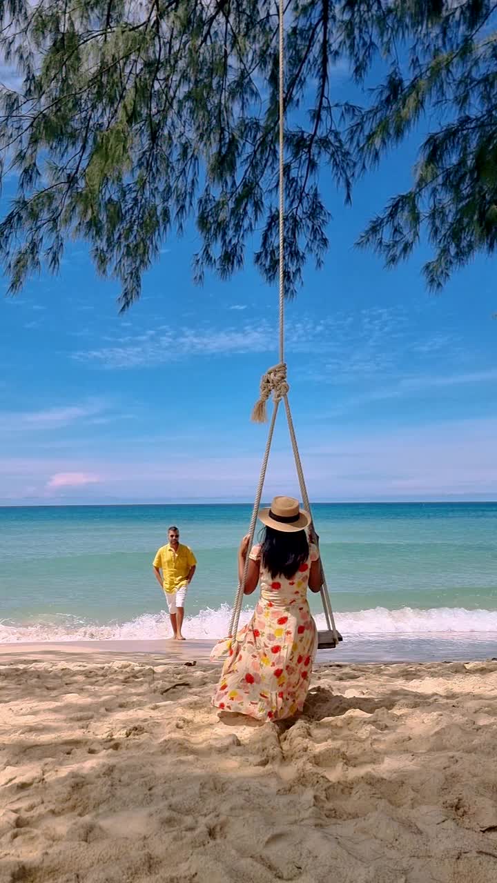 一对男女在泰国Koh Kood海滩上玩秋千视频素材