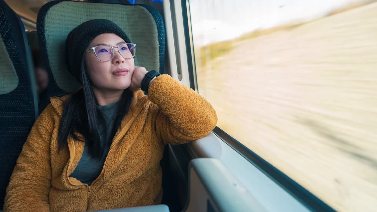 亚洲女性坐火车旅行，出差时使用智能手机和科技笔记本电脑工作的时间推移视频下载