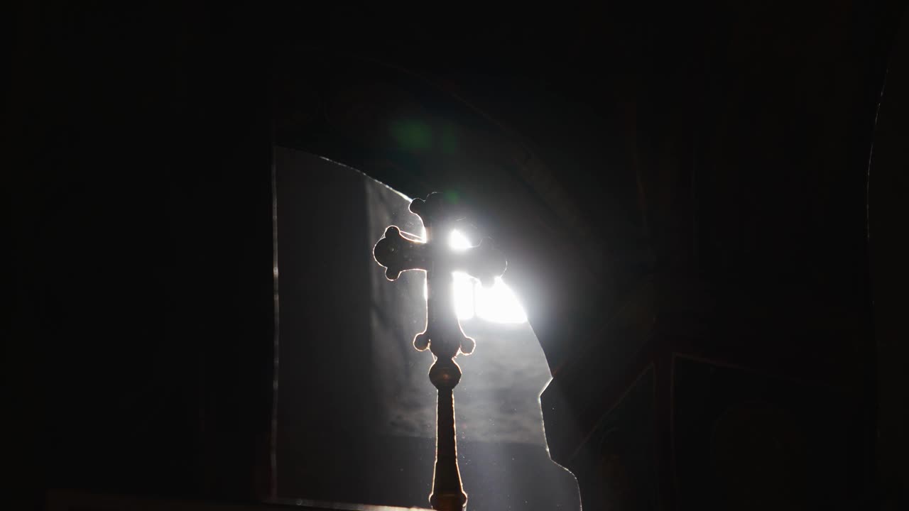 一个正统的十字架的剪影在一缕阳光从一个小窗口视频素材