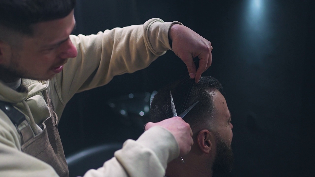 近距离观看理发师使用剪刀和梳子理发视频素材