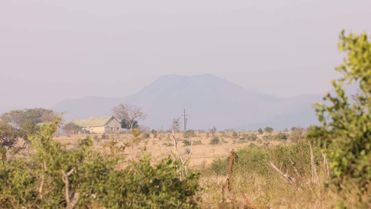 非洲景观与房子在前景山的背景视频素材