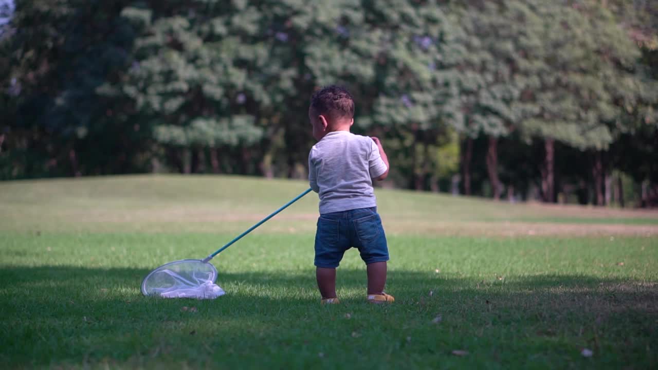 可爱的小男孩在花园里玩玩具，小男孩在户外玩视频下载