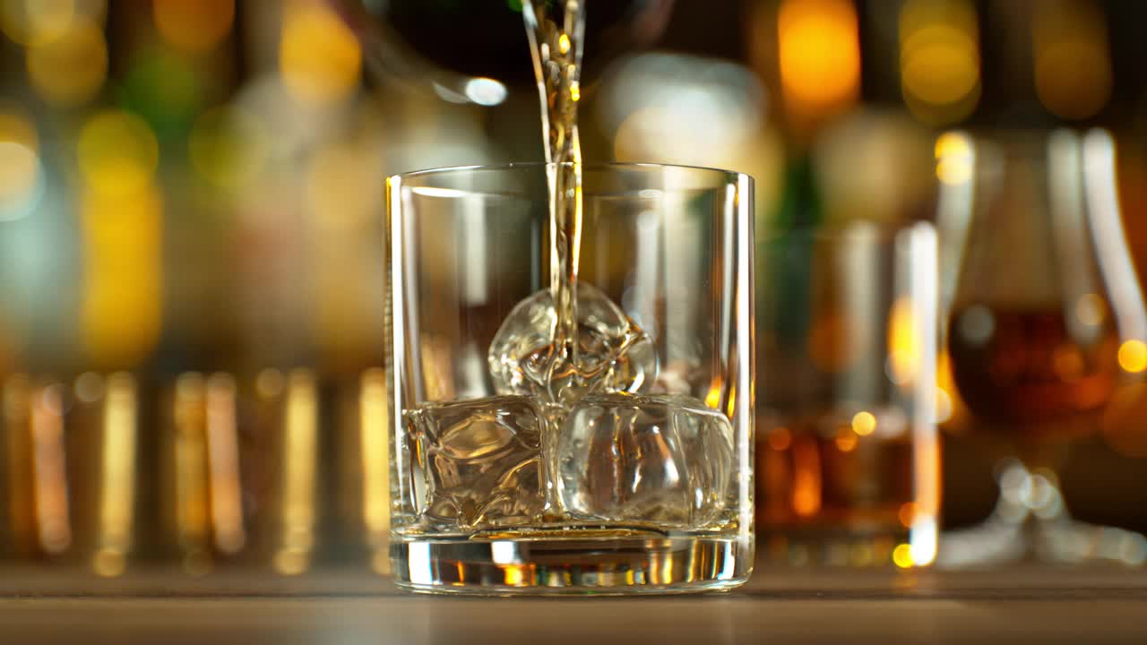 把威士忌倒进玻璃杯的超慢动作。视频下载
