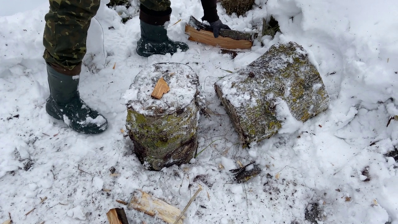 冬天，一个人在村子里用斧头劈柴。视频下载