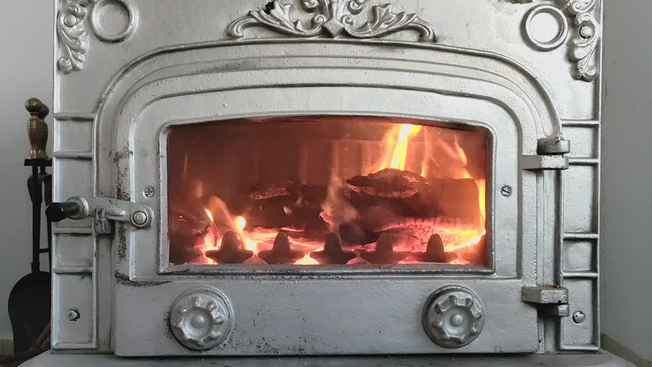 玻璃门后的老式金属壁炉里燃着火视频下载