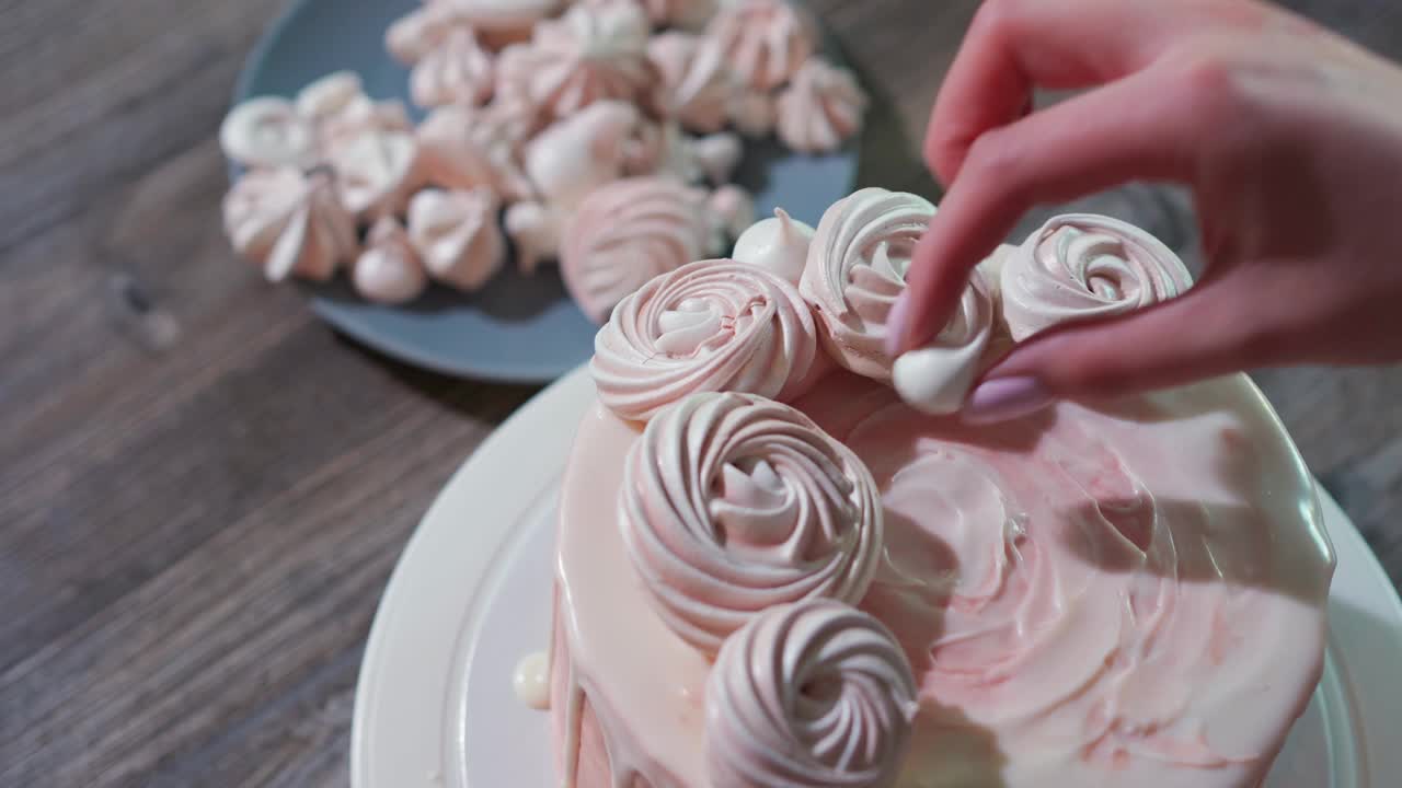 美丽的女性双手在粉红色的蛋糕上摊开一大堆不同大小的贝丝。给女孩的生日蛋糕视频下载