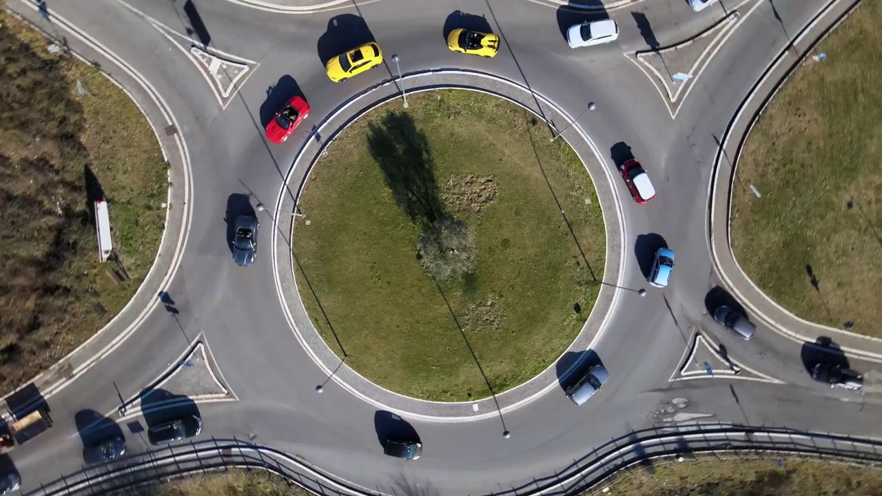 在城市环岛驾驶专属跑车的鸟瞰图，在交通时段在街道上表演的豪华彩车，在道路路口行驶的跑车视频下载