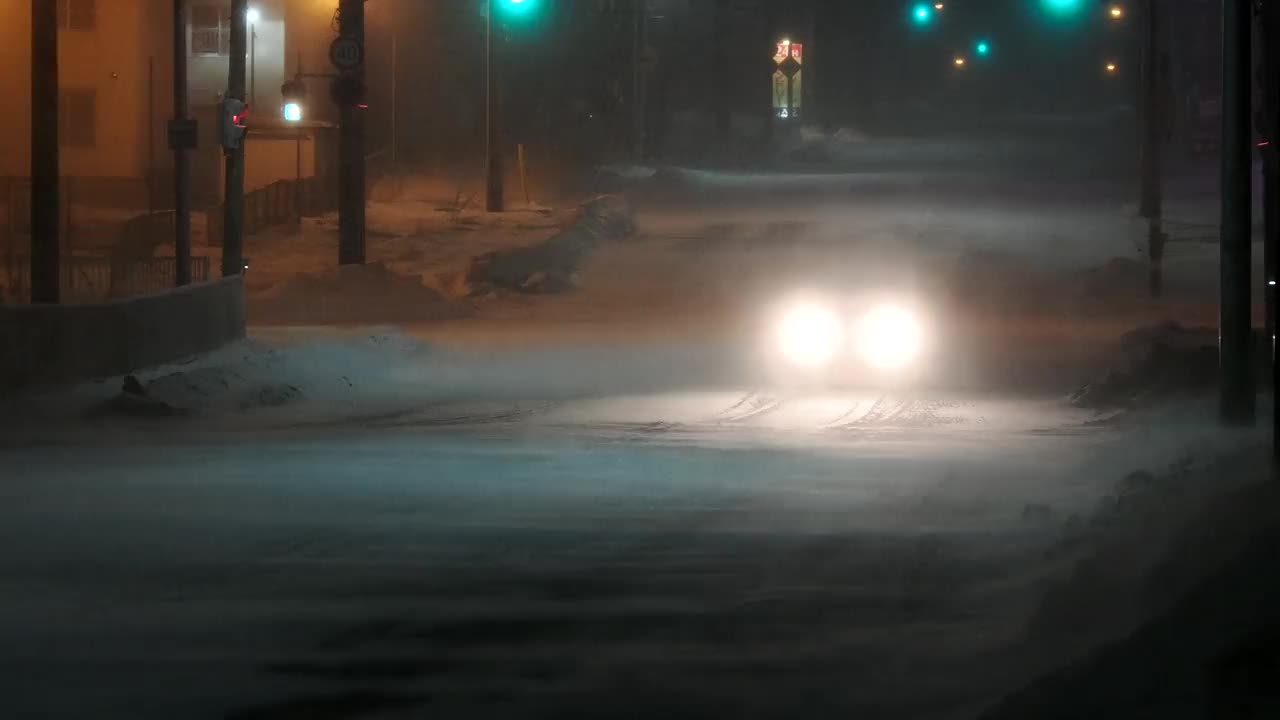 午夜时分，日本北海道内目罗，一辆汽车在大雪和强风中行驶视频素材