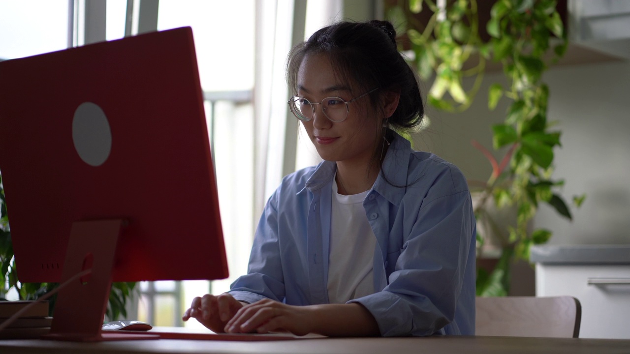 微笑的亚洲千禧女孩在电脑键盘上打字，在社交媒体或约会网站上聊天视频素材