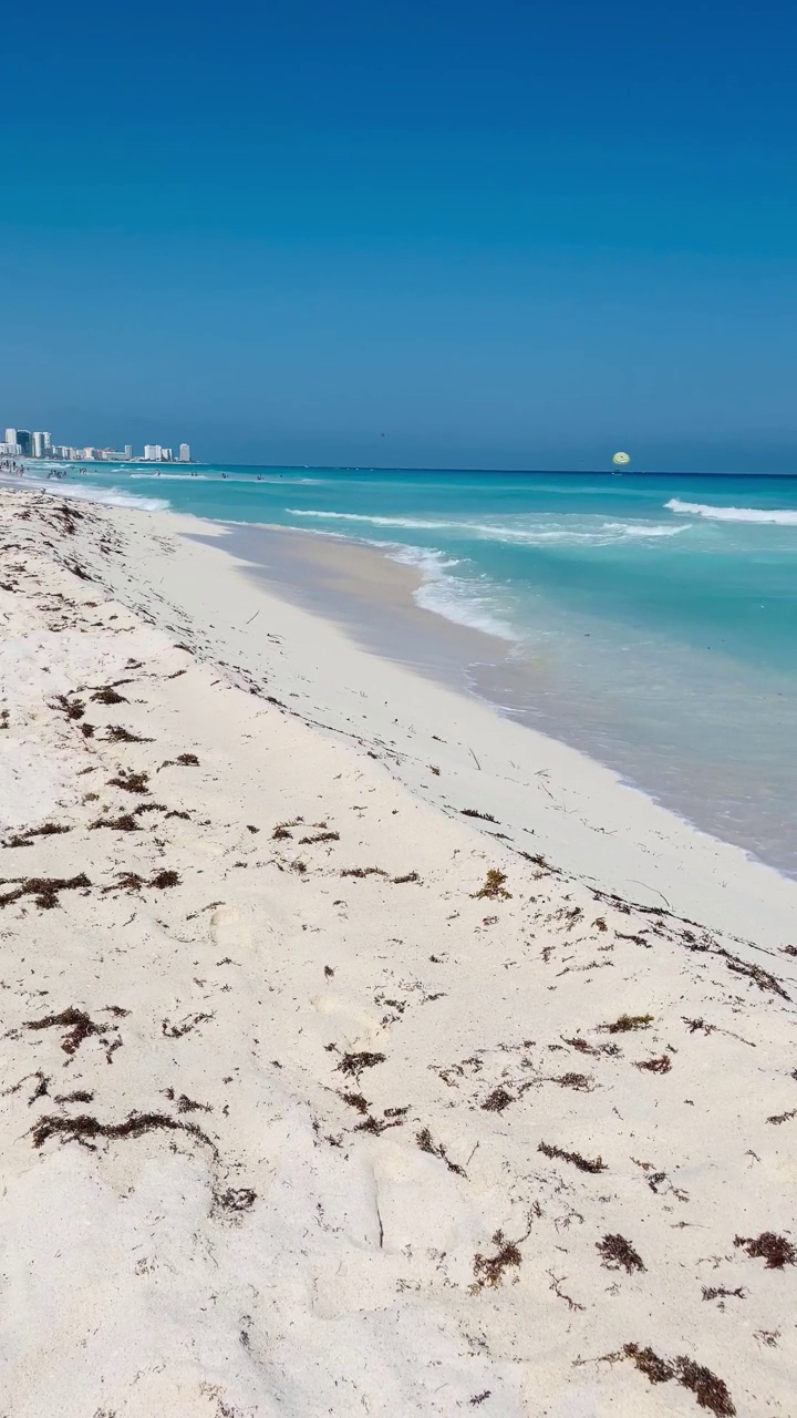 坎昆海滩，蓝色的暴风雨海和白色的沙滩，低角度视角，阳光明媚的一天，墨西哥视频下载
