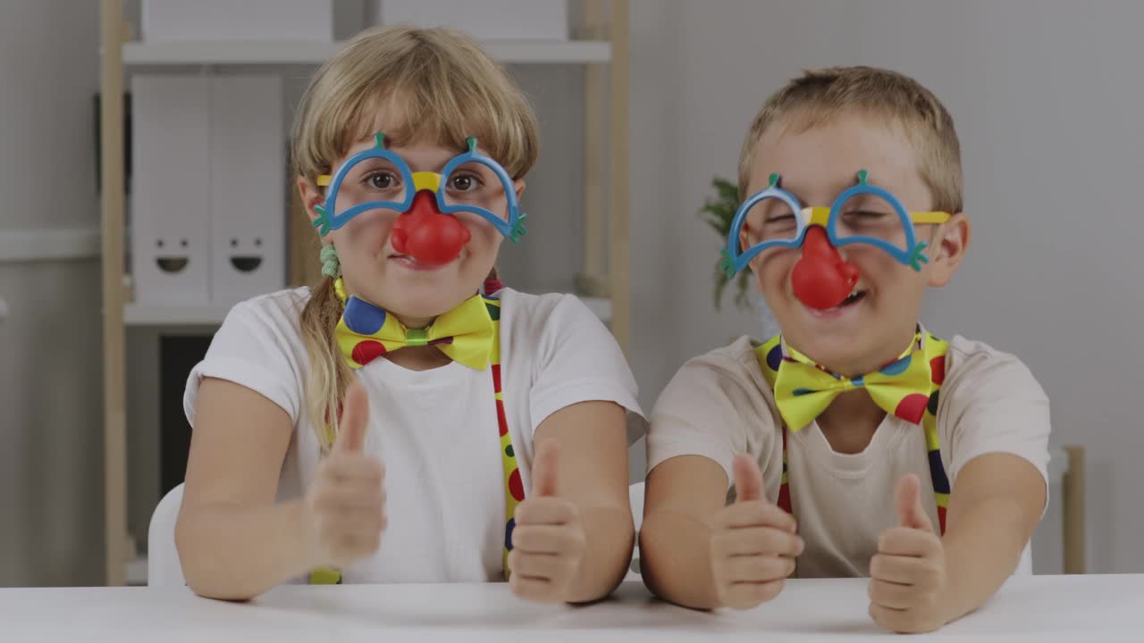男孩和女孩都穿着红鼻子的小丑装。红鼻子日。视频下载