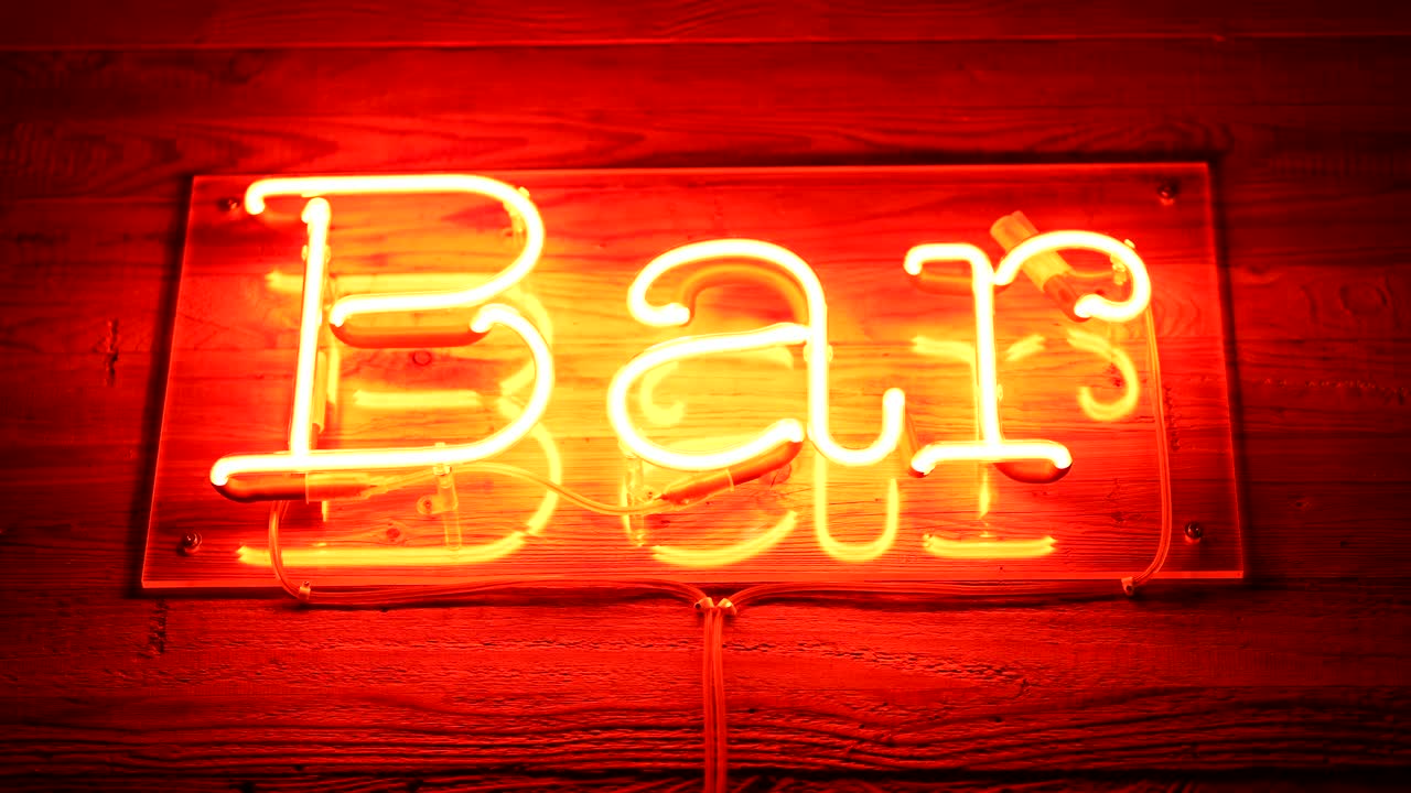 酒吧荧光灯标志在商业入口在红色与木制表面广告业务在手持运动视频下载