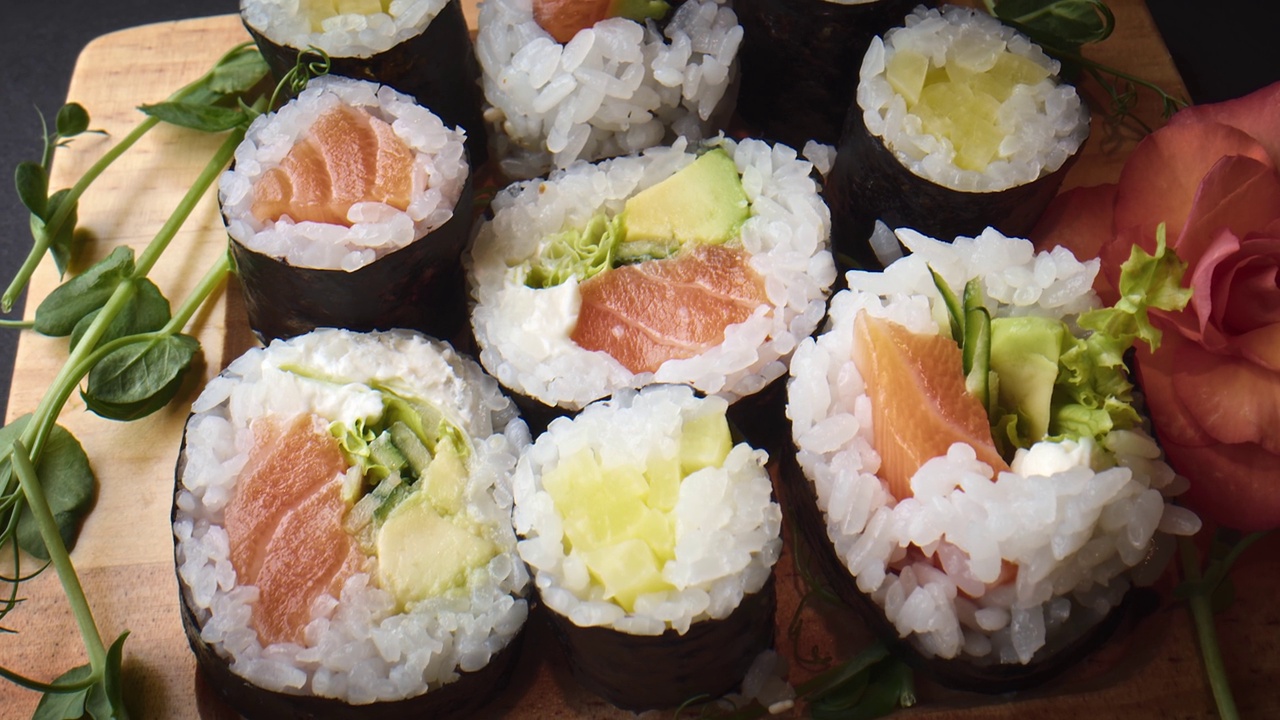 各式各样的寿司卷放在木盘上。视频下载