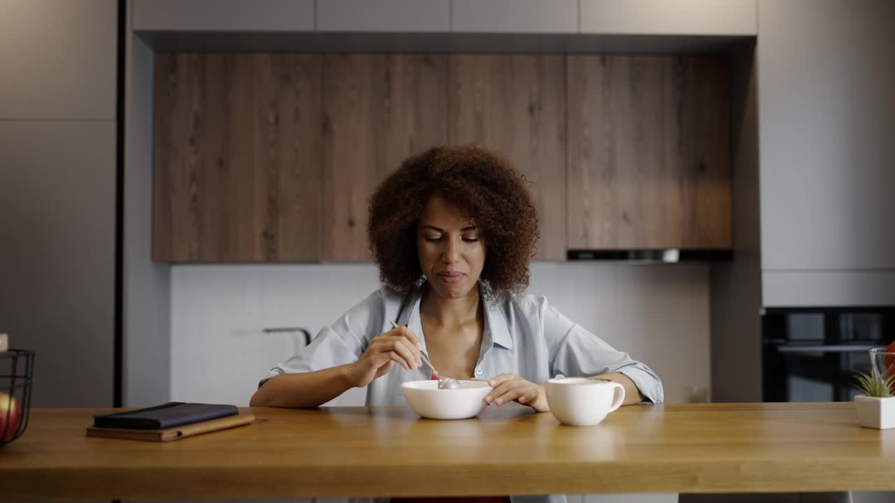非裔美国妇女在家里吃早餐，健康饮食，快乐的早晨视频素材
