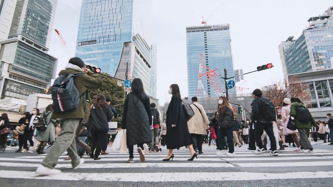 人群走过涩谷十字路口，低角度观看慢动作。东京旅游景点地标、交通交通、日本旅游、亚洲交通、亚洲城市生活理念视频下载