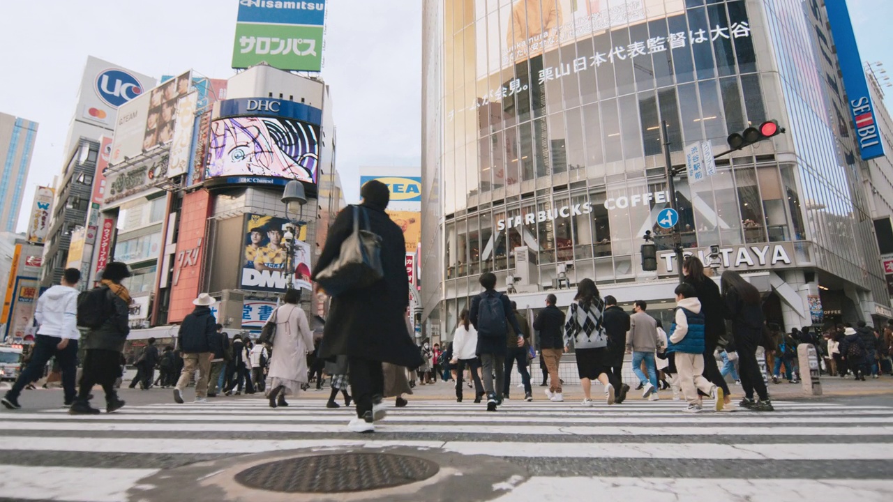 人群走过涩谷十字路口，低角度观看慢动作。东京旅游景点地标、交通交通、日本旅游、亚洲交通、亚洲城市生活理念视频下载