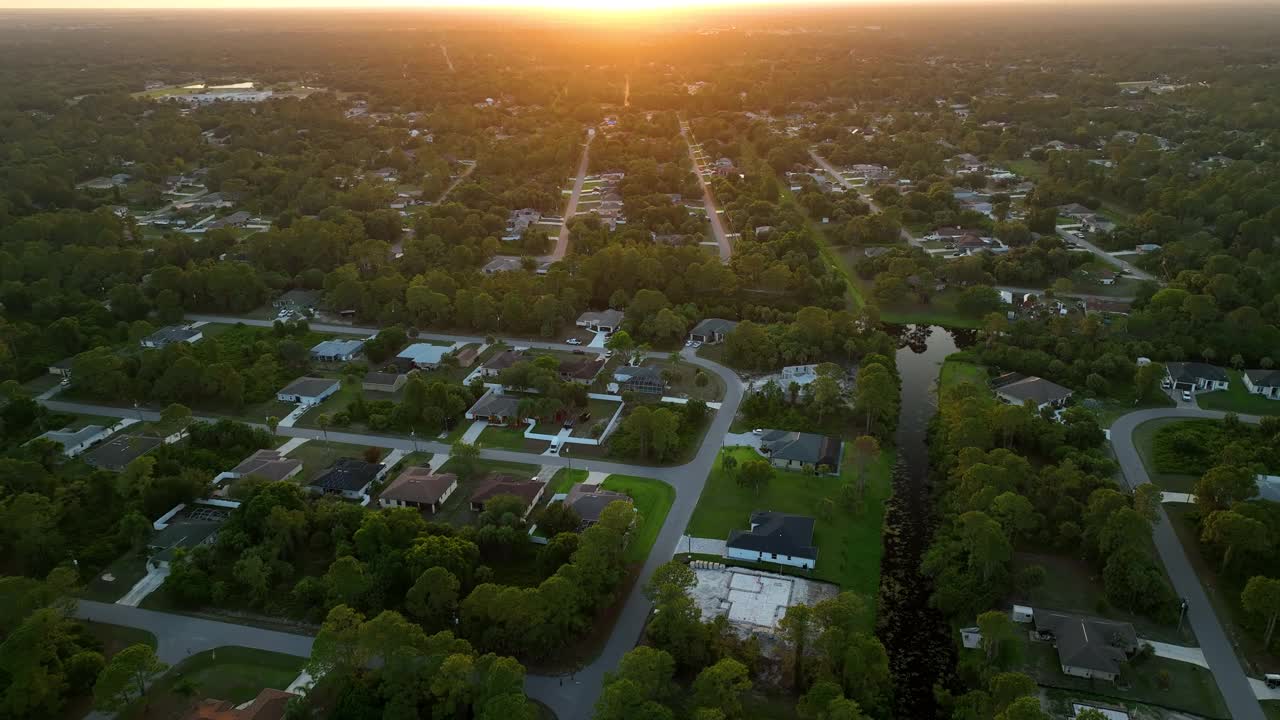 空中景观的郊区私人住宅之间的绿色棕榈树在佛罗里达州安静的农村地区日落视频素材