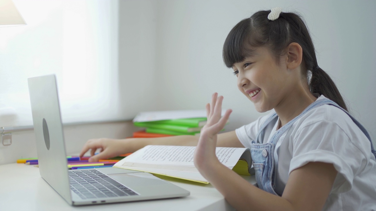 快乐的年轻微笑的孩子孩子女孩的肖像，亚裔泰国妇女在家里学习电脑笔记本电脑上网，人们的生活方式。视频下载