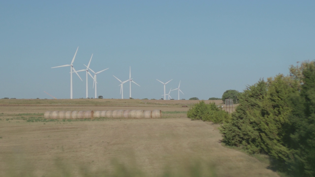 SLO MO组风力涡轮机在阳光明媚的日子里迎风旋转视频素材