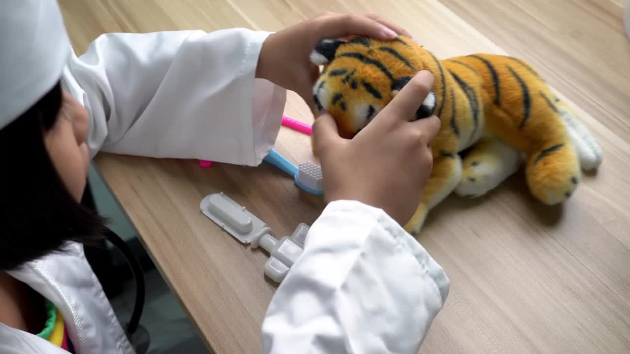 一个女孩假装医生检查老虎玩具的眼睛视频下载