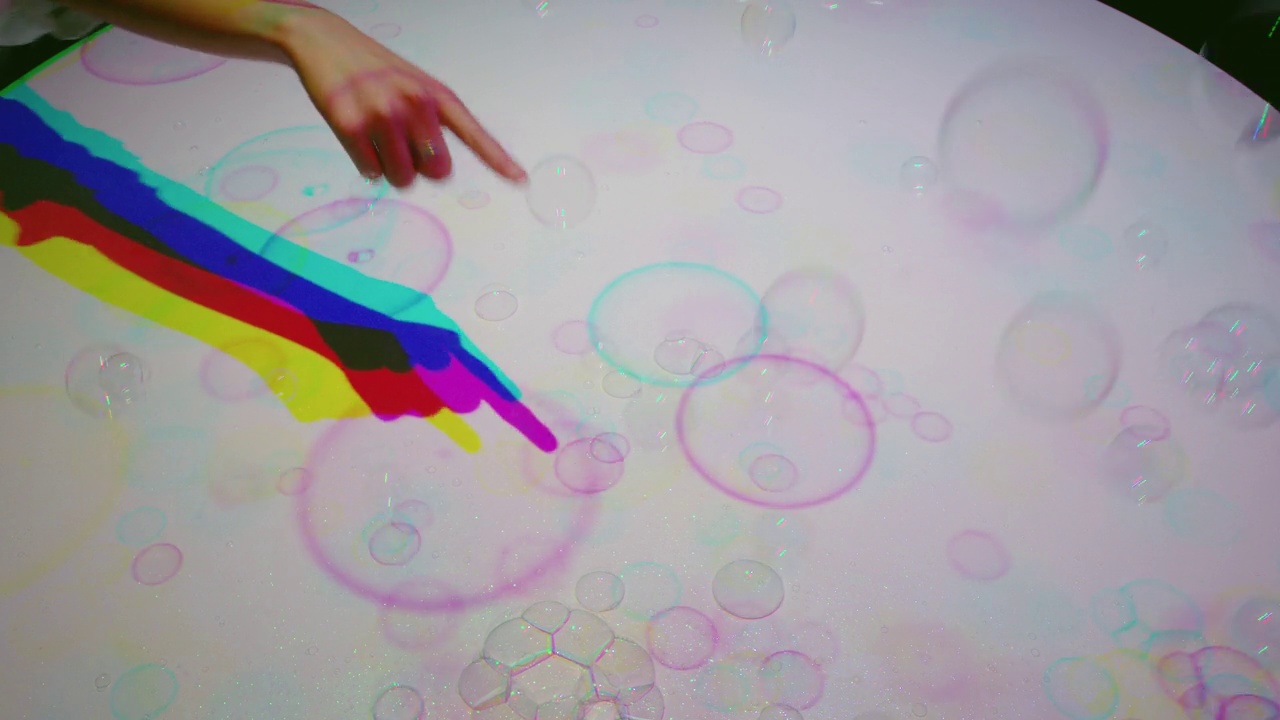 五彩缤纷的手弹出泡泡孩子玩得很开心与五彩缤纷的光孩子玩游戏与彩虹色彩快乐的童年概念视频素材